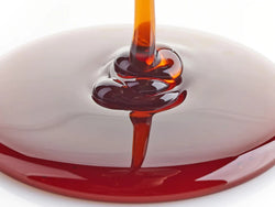 Caramel sauce in spoons pouring over