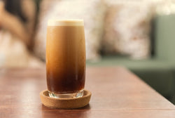 Cold brew nitro coffee in a tall glass, showing its creaminess. 