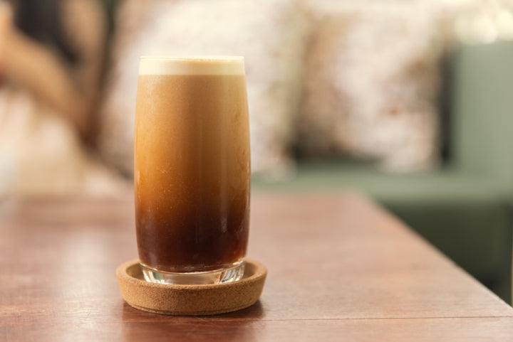 Cold brew nitro coffee in a tall glass, showing its creaminess. 