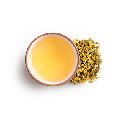 Tea cup with yellow liquid and dried chamomile flowers 
