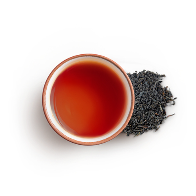 Tea cup with red tea and black tea leaves 