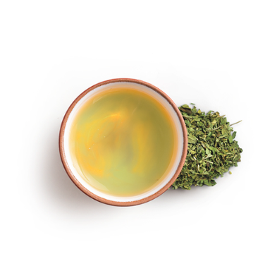 Tea leaves and a cup of green tea on a white background